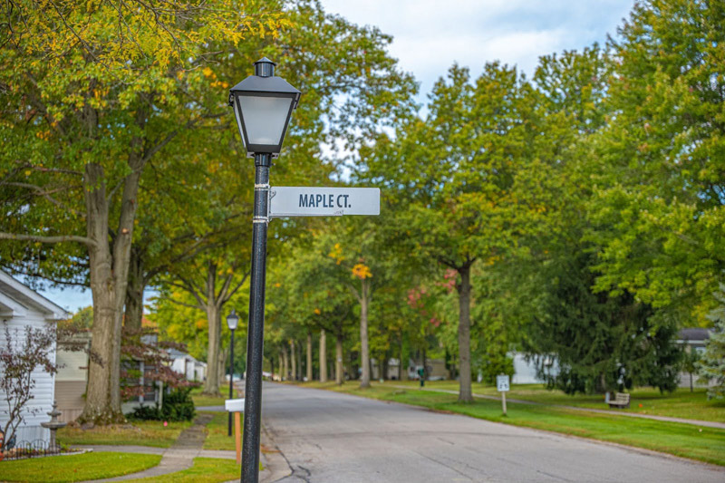 Tree-lined street at Columbia Park 55 and older community in Olmsted Township Ohio with Maple Court sign