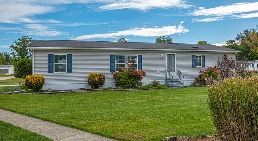 Single-story manufactured home exterior at Columbia Park 55+ community in Ohio with landscaped lawn and front entry steps